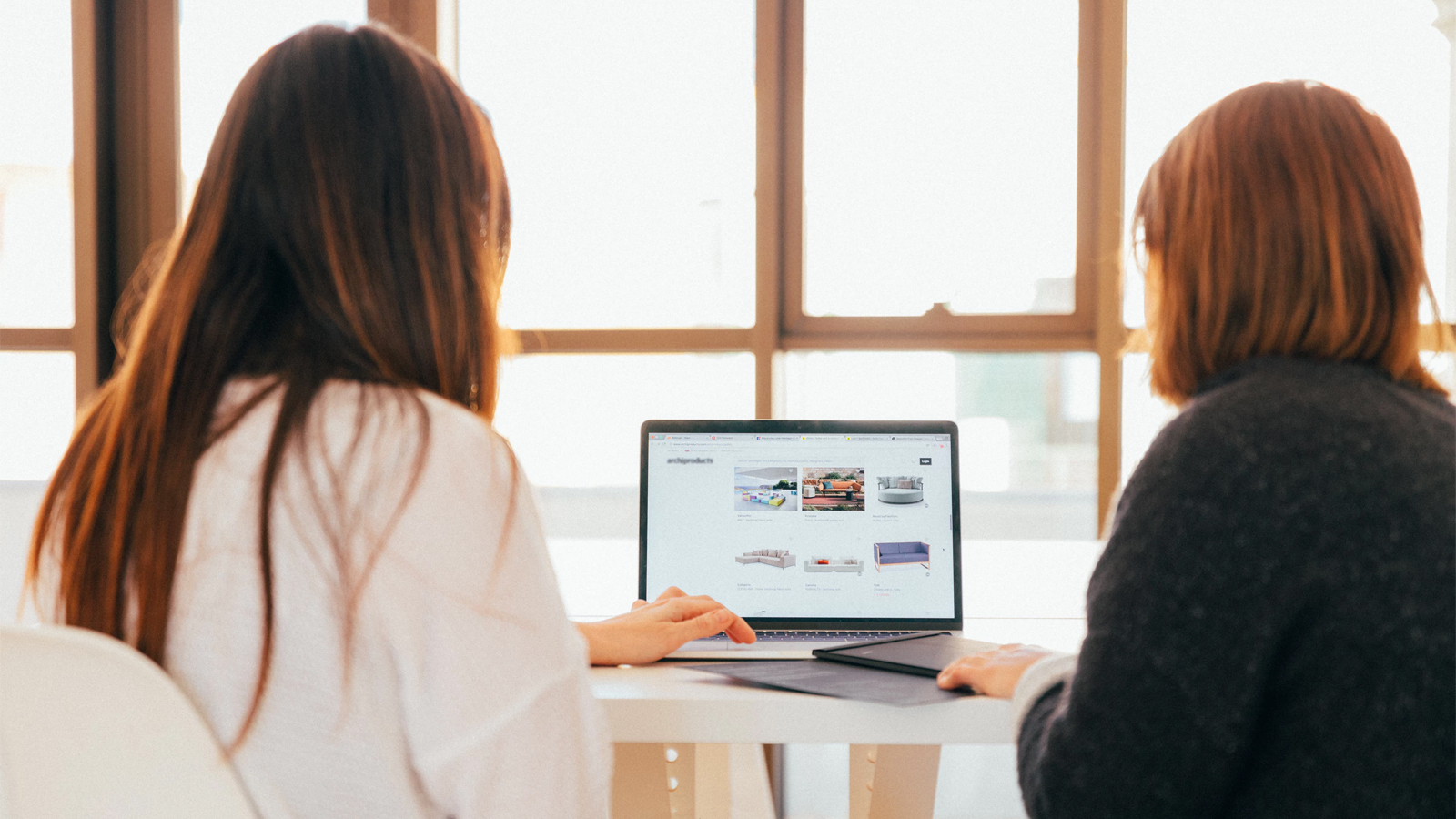 Two women reading a blog on a laptop computer.