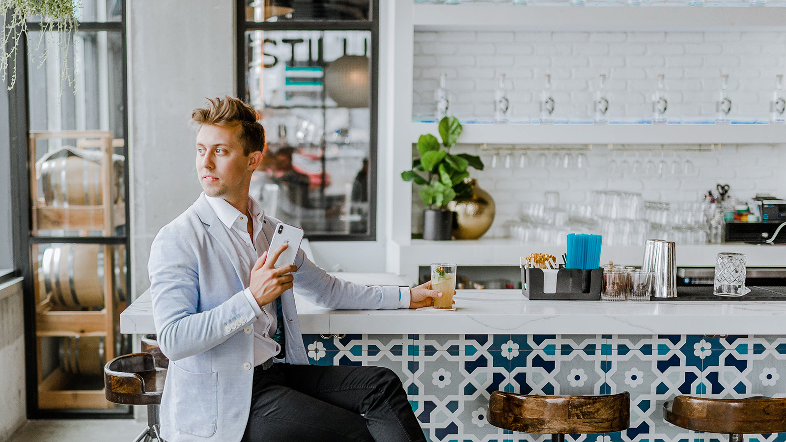 Man sitting at bar holding his smart phone.